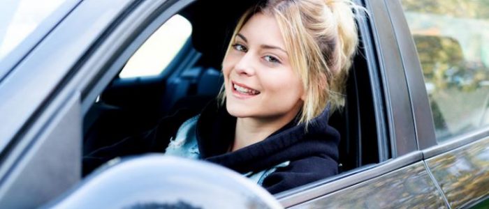 un femme dans la voiture souriante